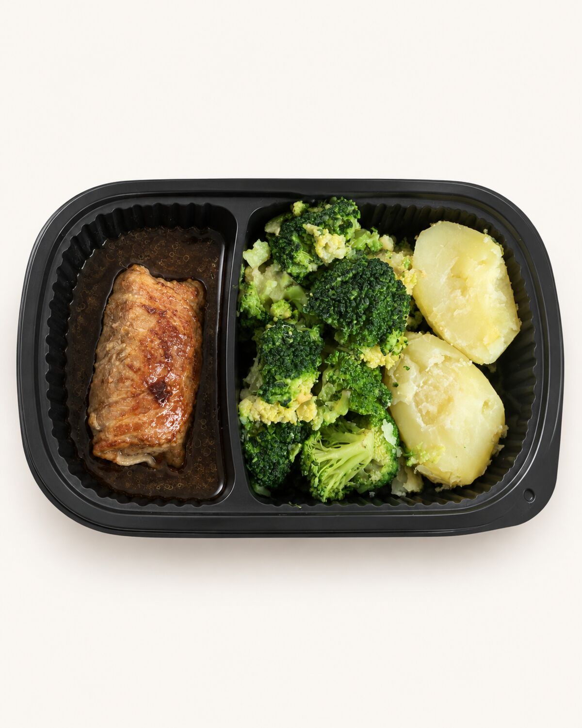 Maaltijdbak met een gebakken slavink, broccoli en gekookte aardappelen.